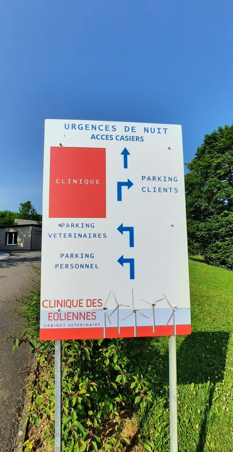 Panneau à l’entrée de la clinique : urgences de nuit, accès aux casiers et parkings